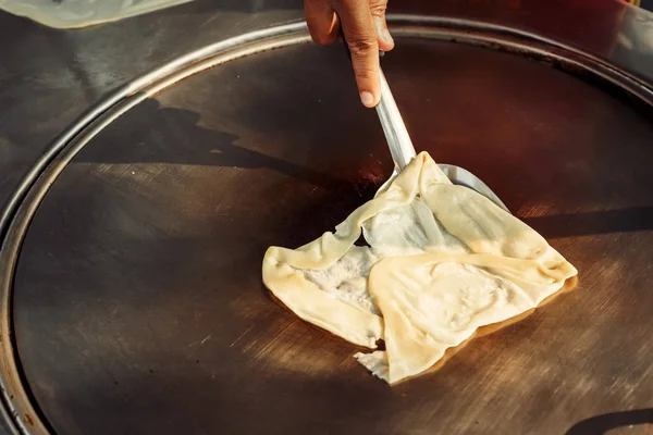 Çelik roti tava veya büyük düz kızartma tavası üzerinde Sokak satıcı pişirme Tay tarzı tatlı roti ekmek El. 
