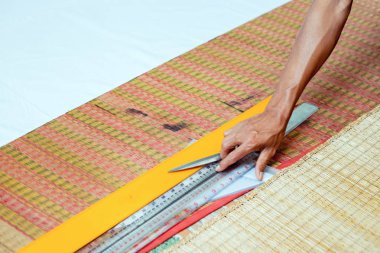 Scissors and ruler on the ground and hand working.