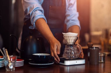 Cam bardakla kahve damlalarını ölçüyorum. 