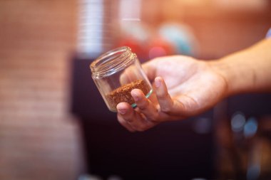 Barista kahve çekirdeklerini bardakta gösteriyor..
