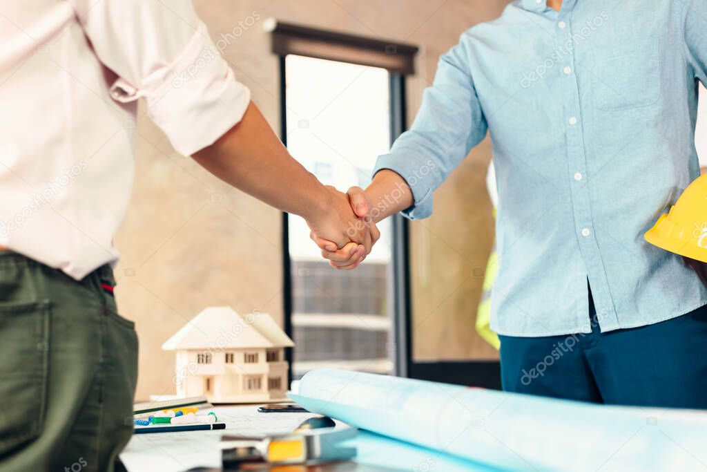 Architect and businessman handshake after finish an agreement in the office at  site construction.