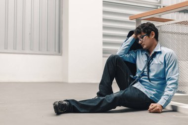 Yorgun iş adamı yerde oturuyor. İşsiz, işsiz konsepti.