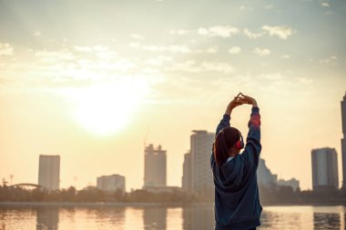 Genç bir kadın sabahları egzersiz yapmadan önce geriniyor..