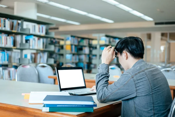 Students studying in the library with laptop at the university. Education concept.