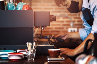 Barista kafede kahve makinesiyle taze kahve yapıyor.