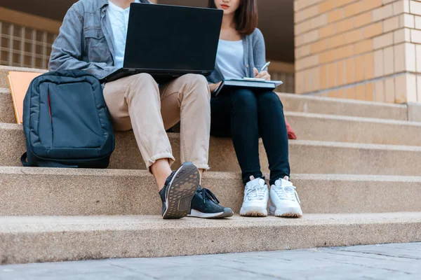 10代の若者が大学のキャンパスの階段に座って学校の本やノートパソコンで宿題をしています 教育理念 — ストック写真