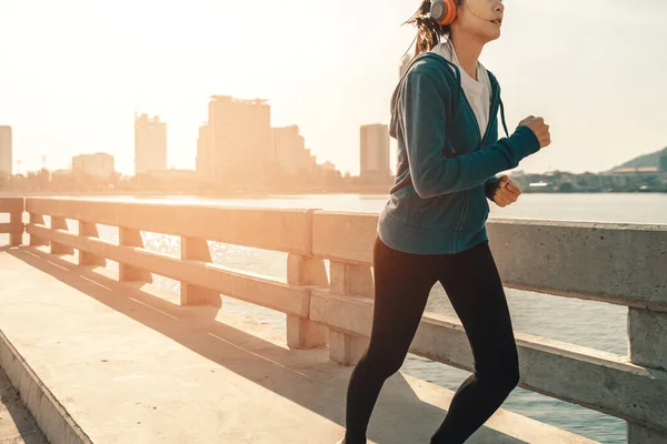 Young sport woman running and city background. Healthy and sport outdoor concept.