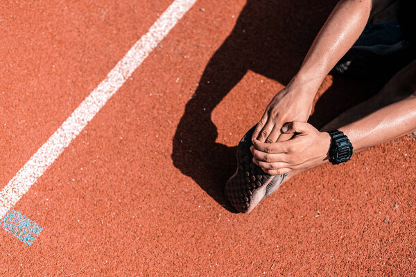 Молодой человек растягивает мышцы до и после тренировки. Фитнес и спортивная концепция.