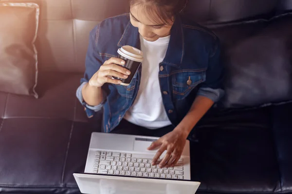 Mujer Joven Sentada Sofá Cafetería Tomando Café Mientras Trabaja Computadora — Foto de Stock