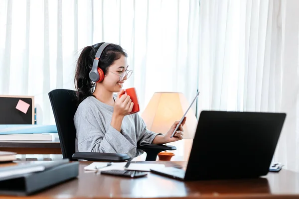 Kobieta Pracująca Laptopie Trzymać Filiżankę Kawy Podczas Siedzenia Miejscu Pracy — Zdjęcie stockowe