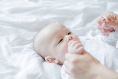 Mutlu anne ve bebek evdeki yatakta birlikte oynuyorlar. Aile sevgisi kavramı.