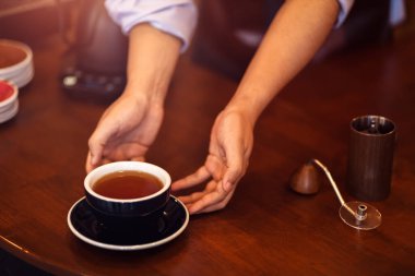 Barista masaya kahve servisi yapıyor. 