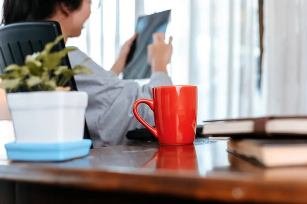 Kvinde Der Arbejder Laptop Holde Kop Kaffe Mens Sidder Arbejdspladsen - Stock-foto