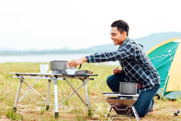 Men cooking while lake camping