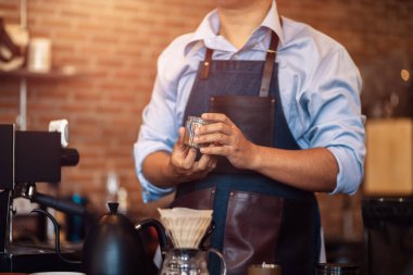 Barista kahve çekirdeklerini bardakta gösteriyor..