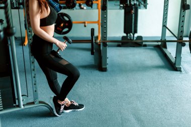 Fitness kızı spor salonunda dambılı kaldırıyor. Spor ve kas konsepti.