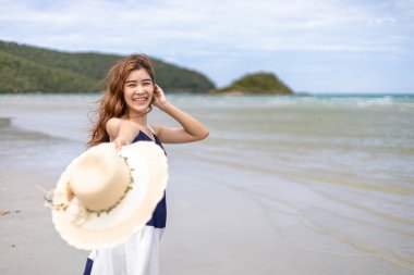 Yazın çıplak ayakla yürüyen bir kadın. Deniz suyu dalgası ve kumsalda kum.. 