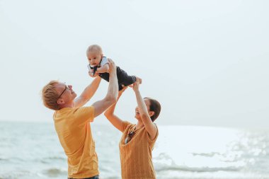 Kumsalda mutlu bir aile. Baba, anne ve bebek yaz tatilinde eğleniyorlar. Tatil seyahati kavramı
