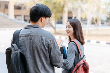 Lise öğrencileri üniversitede kitap ve dizüstü bilgisayar bulundururlar. Eğitim kavramı.