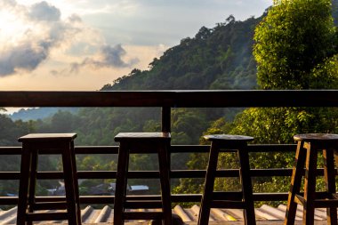 Boş masa ve sandalyeler dışarıda ve dağ manzaralı..
