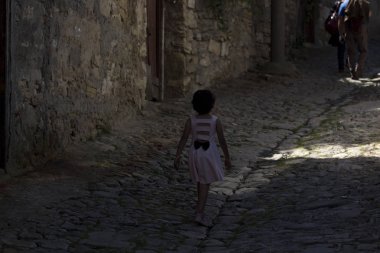 Taş yolda yalnız bir kız yürüyor. Çanakkale, Türkiye