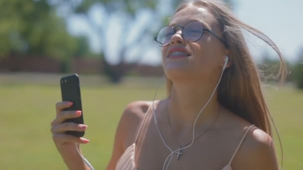 Замедленное Движение Радостная Привлекательная Блондинка Мобильным Телефоном Наушниками Работает Вдоль — стоковое видео