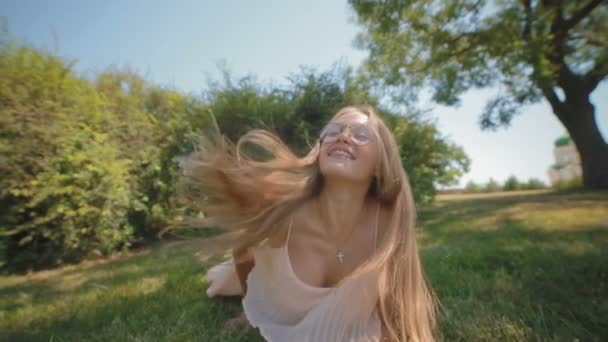 在夏季公园里 戴眼镜的快乐女人倒在新鲜的草地上 — 图库视频影像