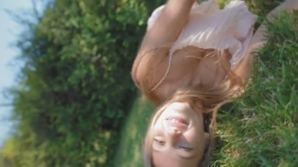 Jonge Vrouw Rolt Weelderige Gras Lachen Camera Draait Side Park — Stockvideo