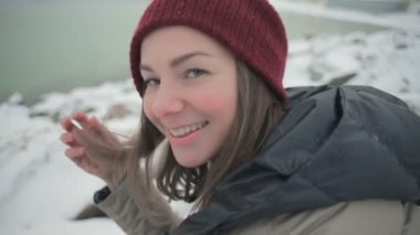  soğuk kış gününde deniz karşı kayalık plaj üzerinde oturan güzel rüya gibi kadın