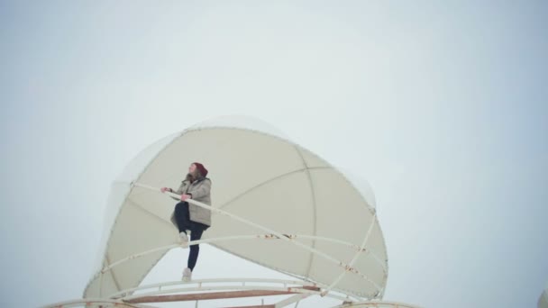 ローアングルの逆アセンブルしたテント ドームの端に立っている美しい少女をショット雪の明確な空の下で手を伸ばす — ストック動画