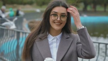 kağıt bardak tutan ve su birikintisi yakın yürüme bardaklarda çekici uzun saçlı kadın