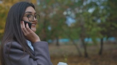  Şehir Parkı içinde cep telefonu konuşurken gözlüklü esmer hanımefendi