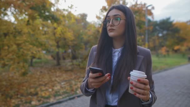 Aantrekkelijke Vrouw Met Grijze Vacht Met Koffiekopje Smartphone Wandelen Herfst — Stockvideo