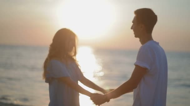 Casal Iluminado Por Pôr Sol Junta Mãos Beijos Praia Areia — Vídeo de Stock