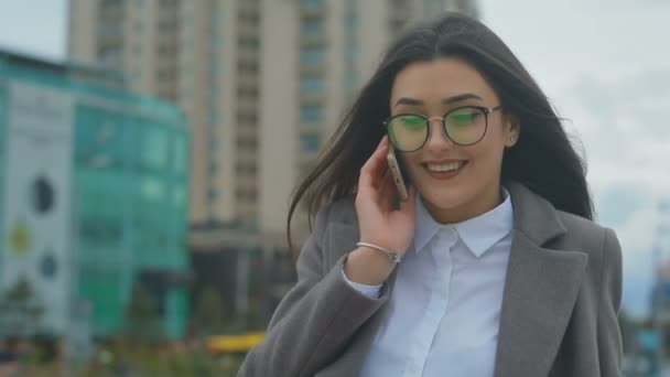 Mulher Morena Alegre Óculos Fala Smartphone Contra Edifícios Modernos Dia — Vídeo de Stock