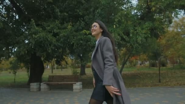 愉快的有吸引力的妇女在灰色外套走在秋天公园 — 图库视频影像