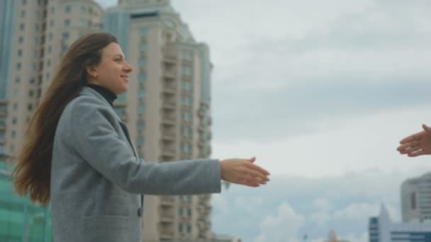 年轻的女同事在街上与秋风多云的天空握手 — 图库视频影像