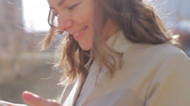 kadın parlak güneş ışığına karşı gülümseyen SMS okur