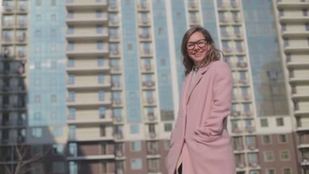 Γυναίκα Γυαλιά Φορώντας Ροζ Παλτό Γυρίζοντας Γύρω Από Κτίριο Την — Αρχείο Βίντεο