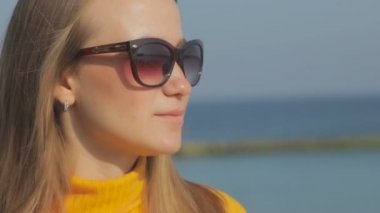 karşı bulanık deniz güneş gözlüğü takıyor rüzgarda sallayarak gevşek akan saçlı kadın