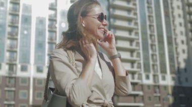 gri çanta ile güneş gözlüğü genç kadın telefonda konuşuyor 