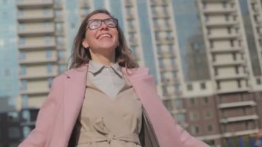 Gözlük kadın ve pembe ceket güneşli bir gün etrafında dönen mutluluk ifade