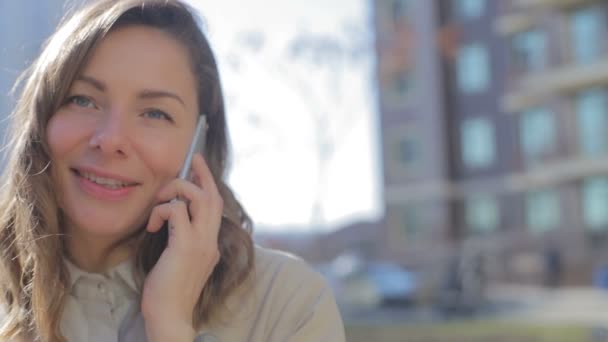 Γυναίκα Μιλά Στο Τηλέφωνο Κατά Του Κτιρίου Την Ηλιόλουστη Μέρα — Αρχείο Βίντεο