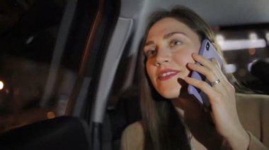 uzun saçlı ve altın yüzük ile gece closeup arabada seyahat akıllı telefon üzerinde muazzam kız