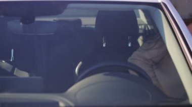 uzun gevşek akan saç ve kırmızı ruj ile kızgın kız beyaz arabaya oturur ve siyah direksiyon yener