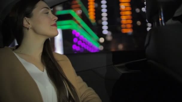 色付きの夜の街のライトに対して車の中で長い緩い流れる髪のドライブと途方もないブルネット — ストック動画