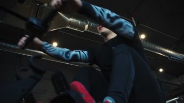 Kel duygusal adam modern spor salonunda kablo sıra makinesi üzerinde egzersiz yapıyor. Düşük açılı yavaş çekim.