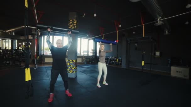 Sterke Paar Hurken Met Speciale Gewichten Handen Moderne Sportclub Met — Stockvideo