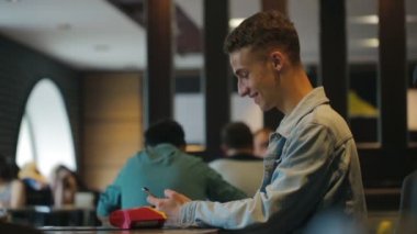 Telefon tutan ve internette sörf yapan genç adam profili
