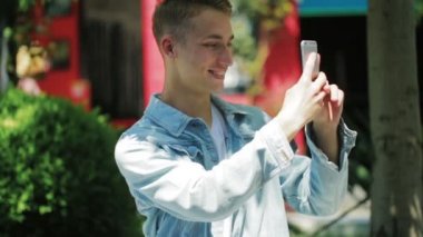 Ceketli hippi elinde metal bir telefon tutuyor ve fotoğraf çekiyor.